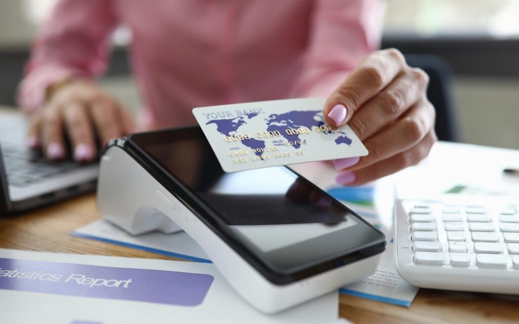 Holds credit card over bank terminal